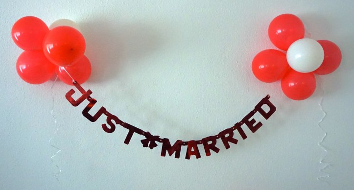 Wedding decor on the wall: a "Just married" garland and balloons