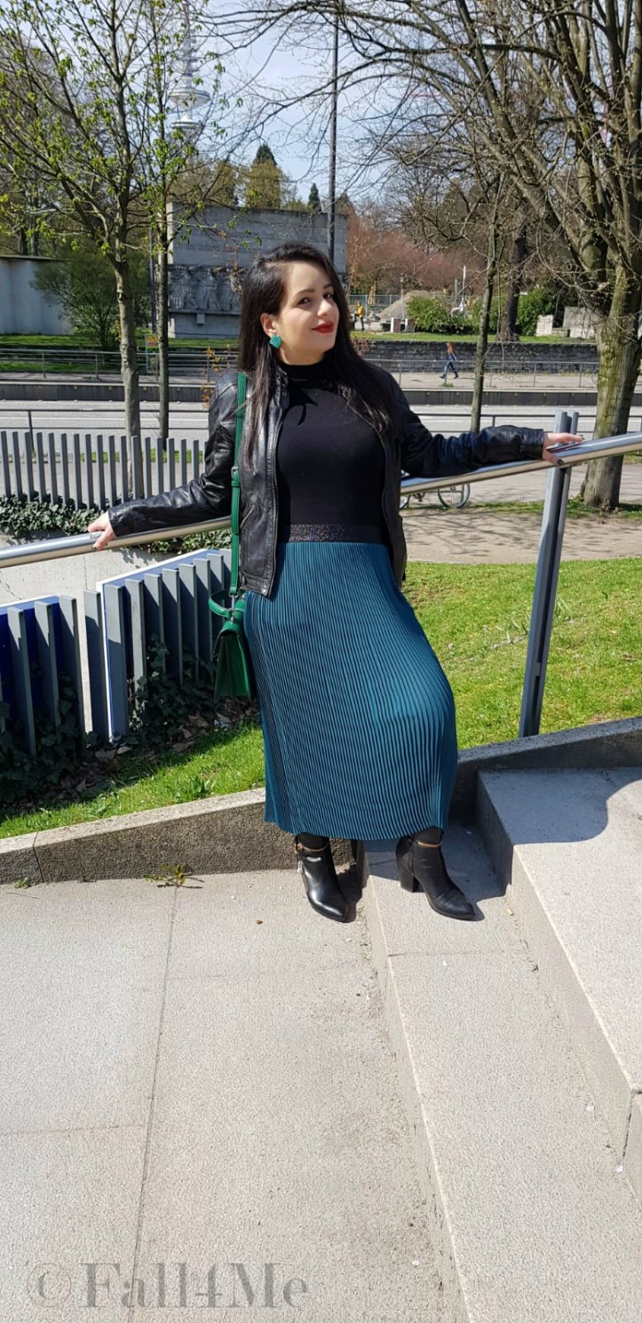 Spring-style in black and green: a leather jacket and a skirt