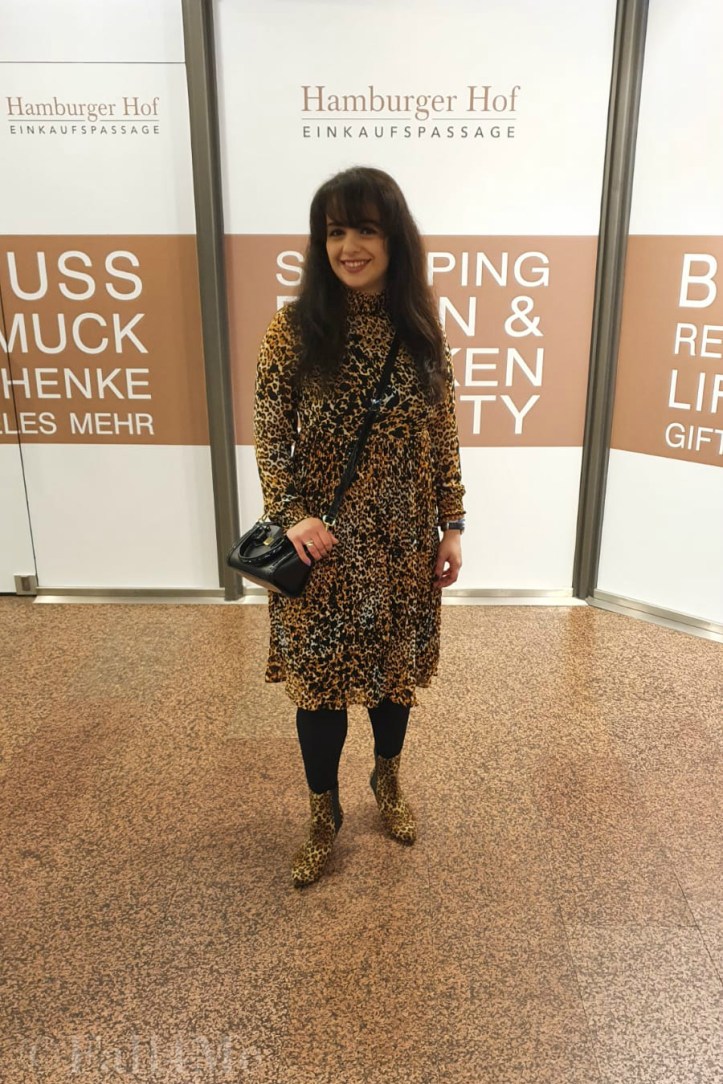 A leo-print dress styled with corresponding ankle boots and black accessories.