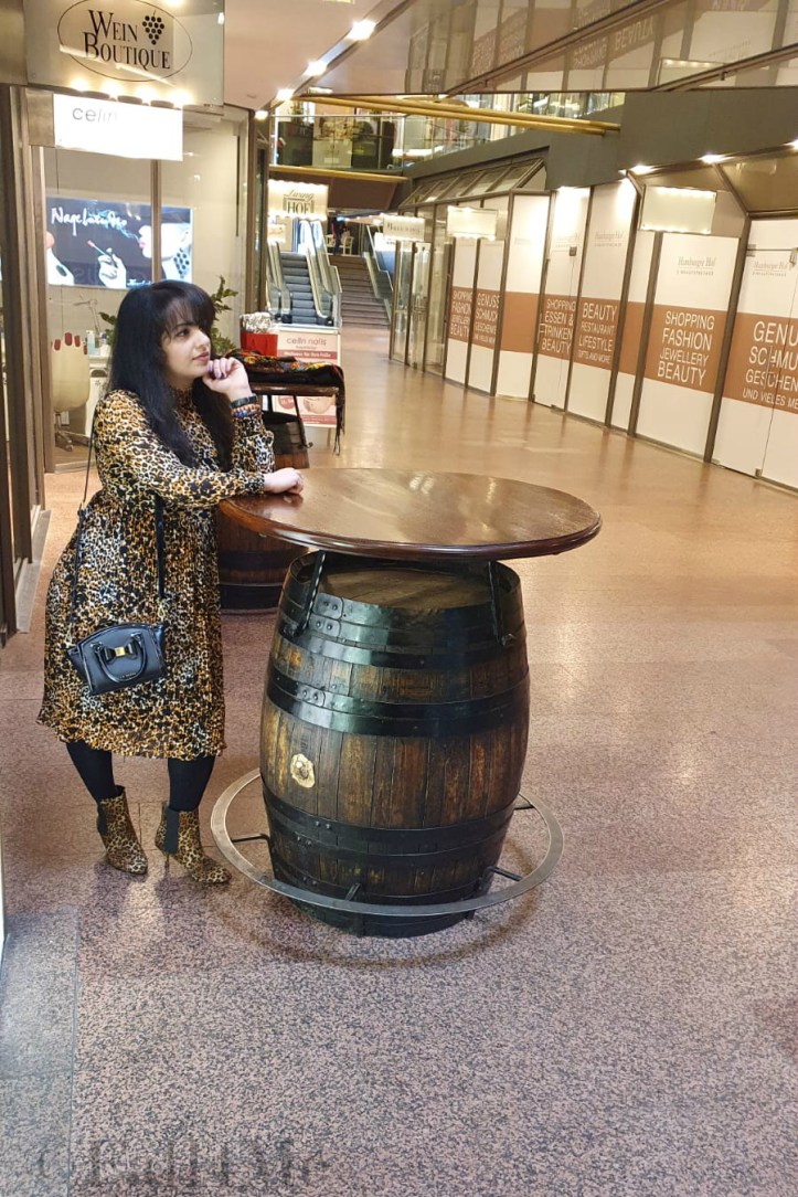 A leo-print dress styled with corresponding ankle boots and black accessories.