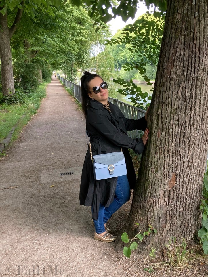 A black trench coat worn with skinny jeans and a leopard printed blouse.