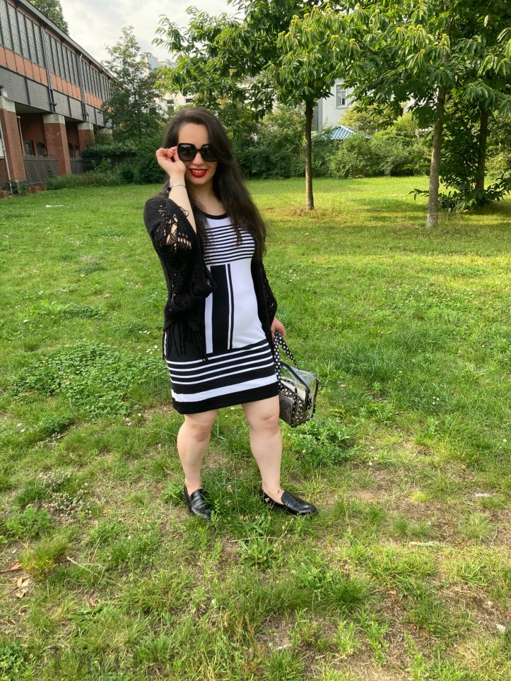 A black and white dress combined with red lips and a transparent handbag.