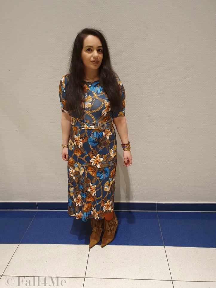 A turquoise dress with flowers in shades of cognac and golden accessories.