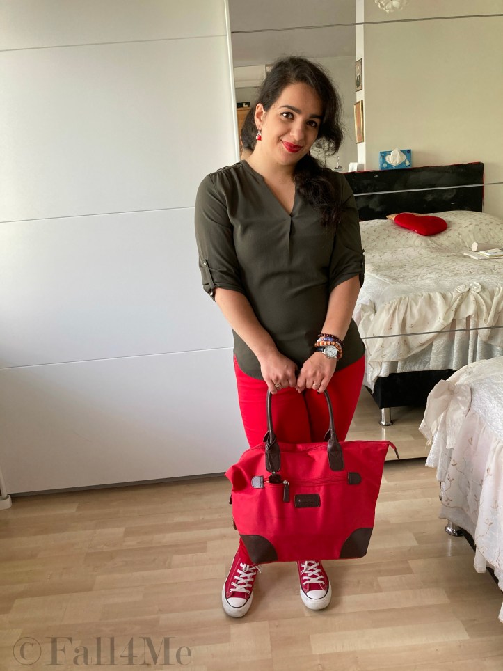 An olive green blouse combined with red lipstick and red skinny jeans and red chucks.