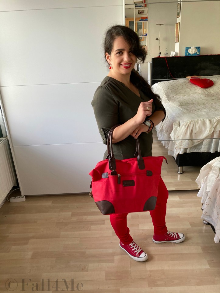 An olive green blouse combined with red lipstick and red skinny jeans and red chucks.