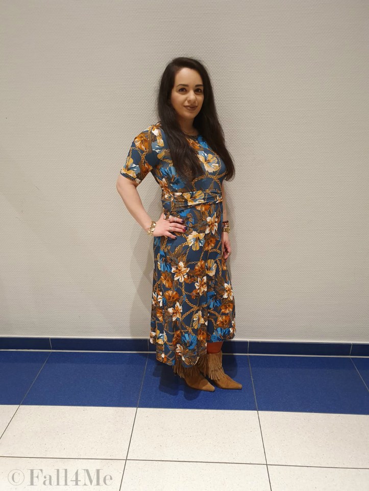 A turquoise dress with flowers in shades of cognac and golden accessories.