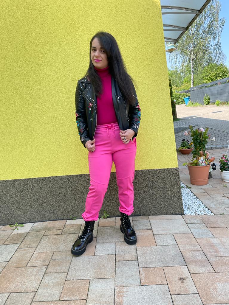 A look and make-up completely in pink with black combat boots with a black leather jacket with floral patches.