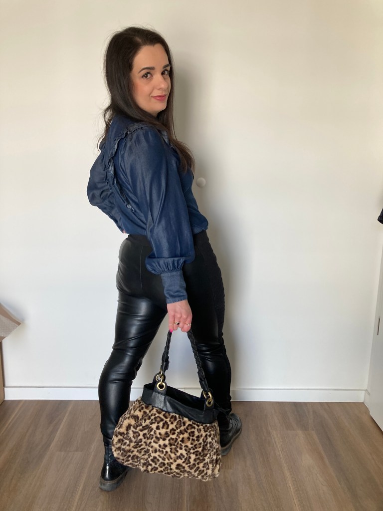 A dark-blue denim blouse combined with black leather leggings and a cuddly leo-print bag.
