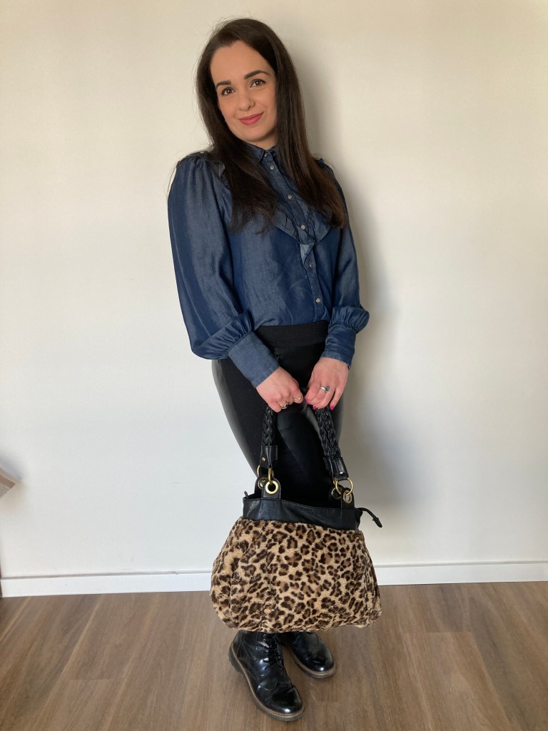 A dark-blue denim blouse combined with black leather leggings and a cuddly leo-print bag.