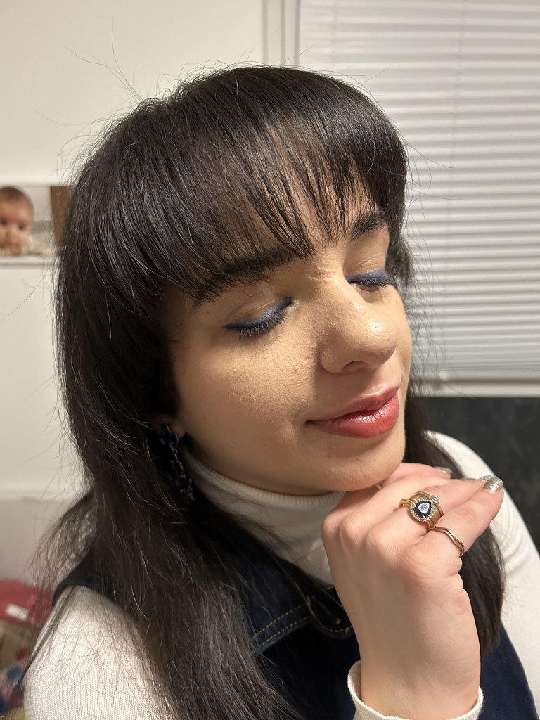 An oversized denim vest worn with a white turtleneck, filigree black combat boots and faux-leather jogpants.