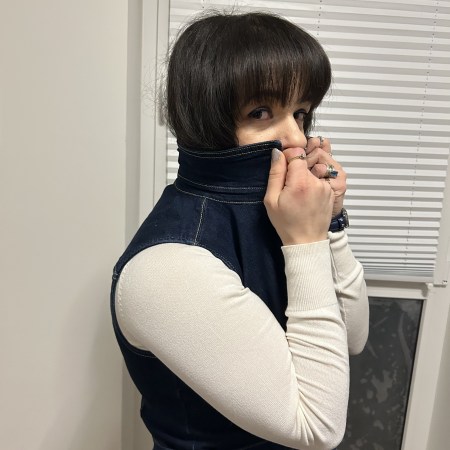 An oversized denim vest worn with a white turtleneck, filigree black combat boots and faux-leather jogpants.