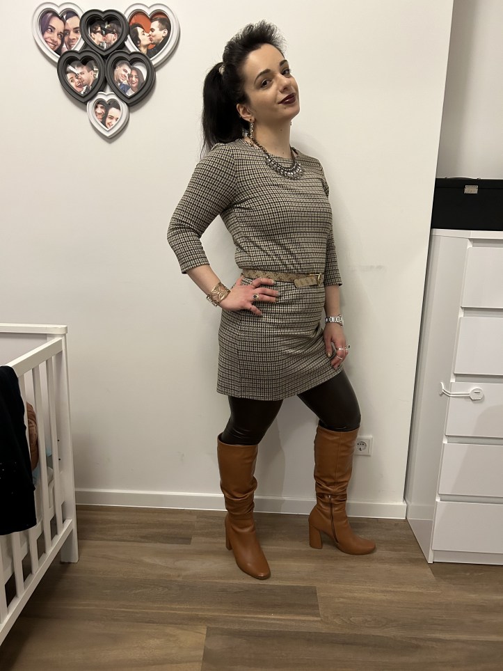 An outfit in corprate core pattern, figure hugging faux-leather leggings in dark green and overknees.