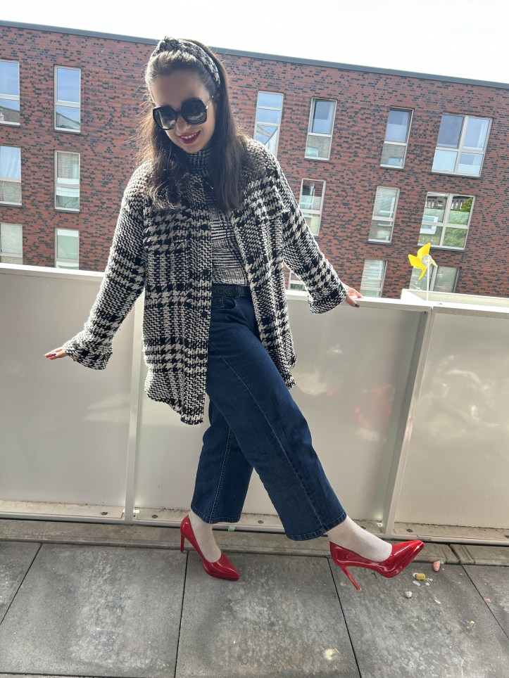 Oversized checked bouclé coat with jeans and red pumps.