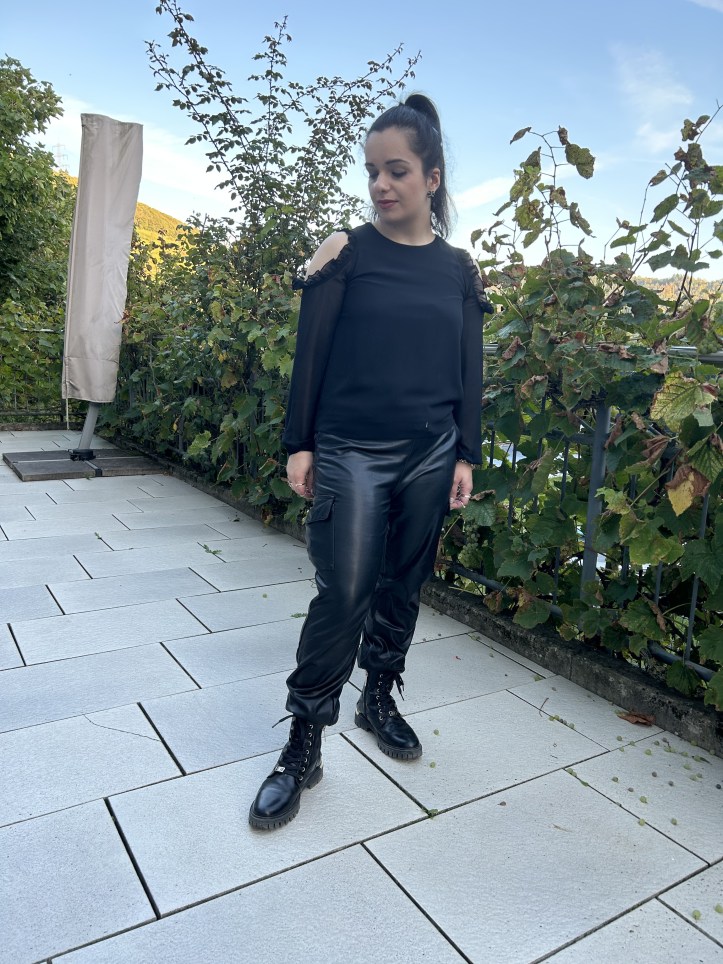 A look in black all over and with faux-leather baggy-pants and filigree combat boots.