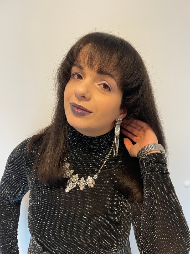 An outfit combining glitter and shiny elements from head to toe with dark berry lips and pastel eyes.