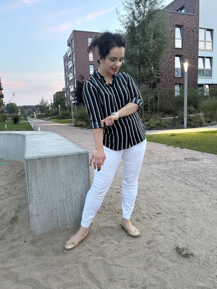 A casual striped shirt worn with white skinny jeans and golden ballerinas.