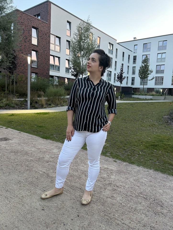 A casual striped shirt worn with white skinny jeans and golden ballerinas.