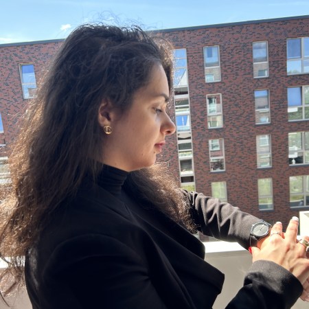 Reduction seduction with a suit all in black with natural curls.