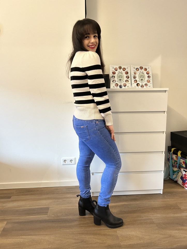 Reduction seduction with a basic look in black and white stripes and jeans with a red handbag.