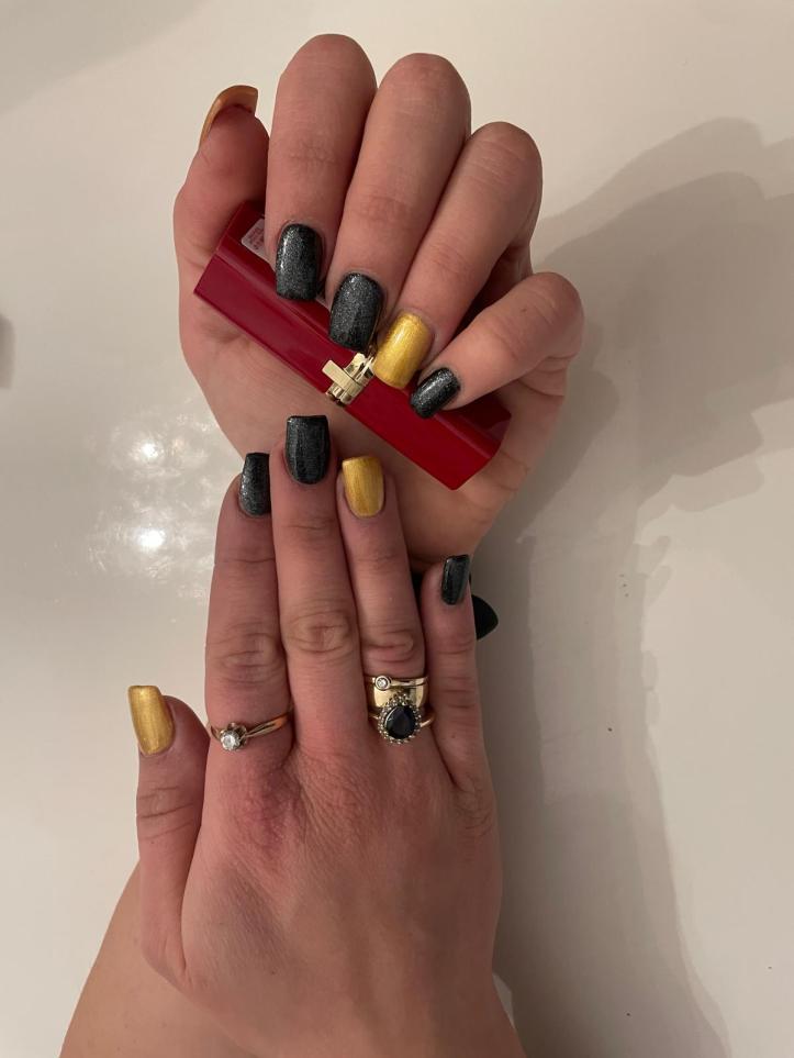 Nails in Black and Gold posing with red lipstick.